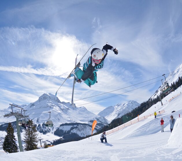 Freestylers in the Snowpark Lech with a view of the Omeshorn.