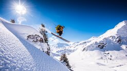 Freerider jumping over a rock in the Warth-Schröcken region